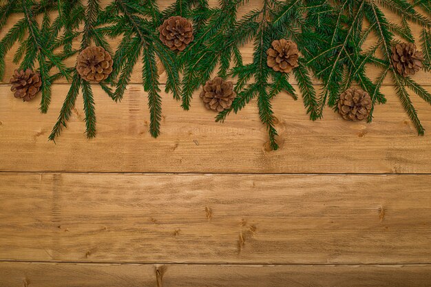 Photo christmas background  fir branches and cones and on dark wooden boards