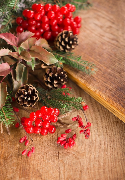 Christmas background made of ipadoub spruce branches cones red viburnum berries on a dark wooden rustic background Christmas background Copy space for text top view