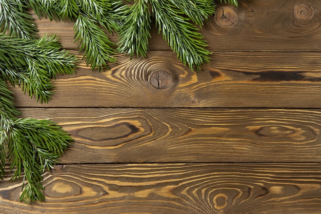 Christmas background. Nobilis fir branches, twigs on brown wooden planks. Copy space, flat lay, top view. Holiday, Xmas, New Year, sales, delivery concept, layout with place for text. Horizontal.