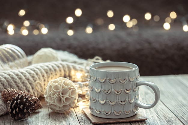 Christmas background with a beautiful cup and decor details on a blurred background with bokeh.