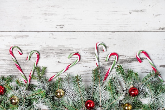 Christmas background with candy canes and Christmas tree on wooden board. Christmas greeting card