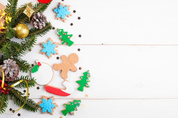 Christmas background with cookies gift fir branches cones flat lay and copy space on white wooden background