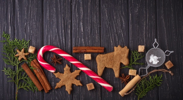 Christmas background with cookies, tree and cinnamon. Selective focus, top view