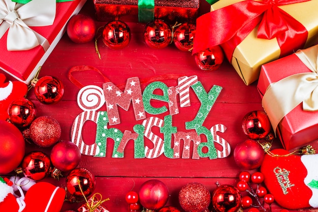 Christmas background with decorations and gift boxes on wooden board