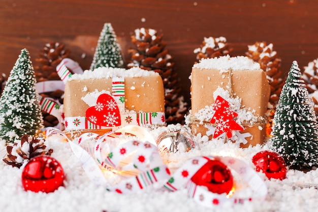 Christmas background with decorations, snow, fir trees, presents and lights. 