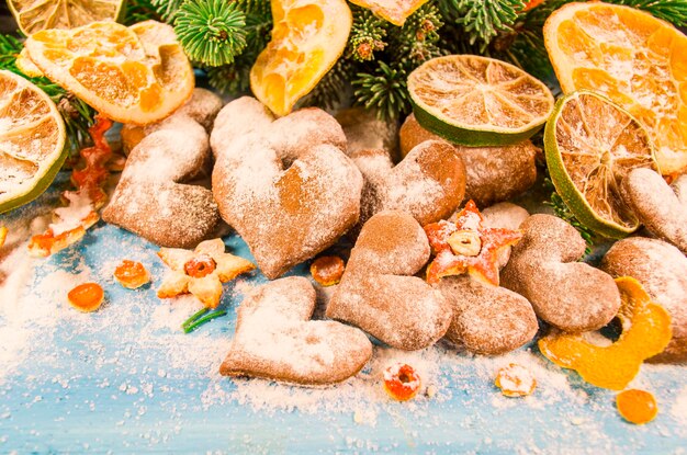 Christmas background with fir branches cookies sprinkled with powdered sugar on wooden board