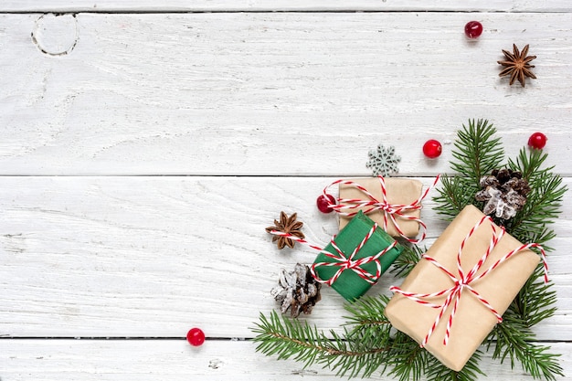 Christmas background with fir branches, decorations, gift boxes and pine cones on white wooden table. Christmas background. Flat lay. top view with copy space