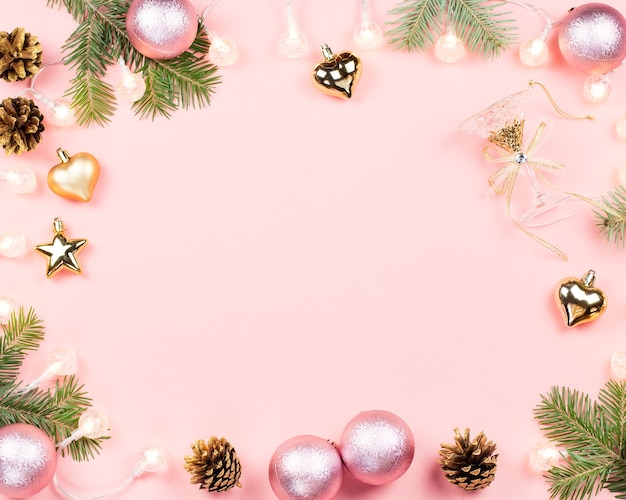 Christmas background with fir tree branches, red giftboxes, decorations, hot drink with marshmallows on pink. Copy space