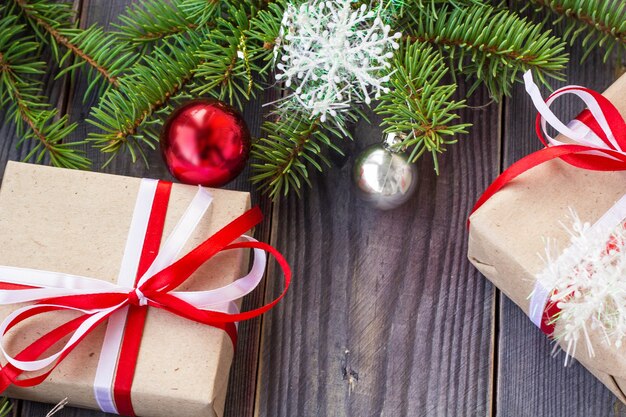 Christmas background with fir tree and decorations and gift boxes on wooden board.