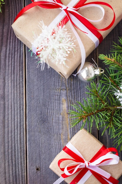 Christmas background with fir tree and decorations and gift boxes on wooden board.