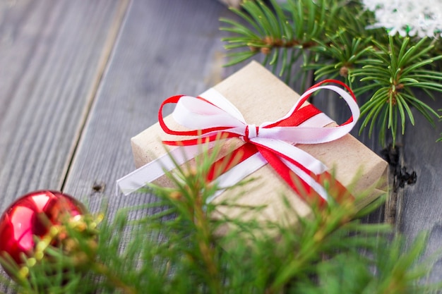 Christmas background with fir tree and decorations and gift boxes on wooden board.