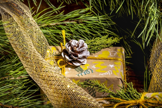 Christmas background with handicraft gift boxes golden clews of rope and decorations with pine