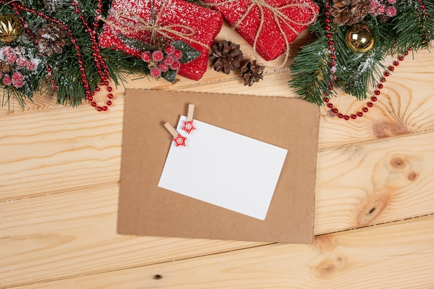 Christmas background with holiday decoration and card, red berries, fir branch and gifts top view