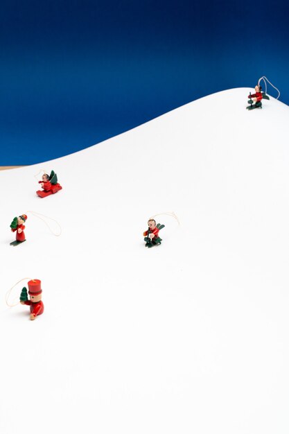 Christmas background with little tree decoration characters snowing in a white paper mountain