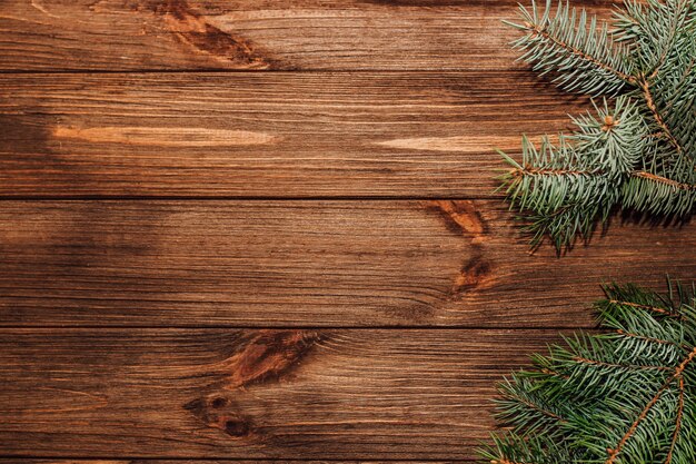 Christmas background with sprig of fir on wooden boards.