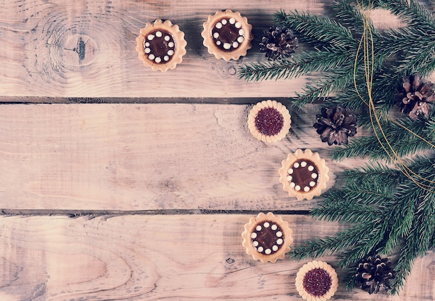 Christmas background with spruce branches and cones with cookies