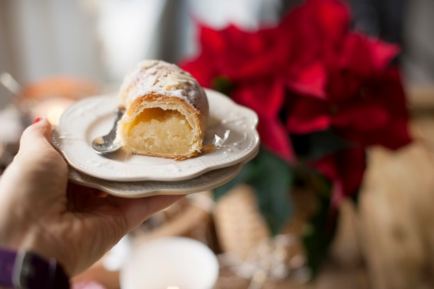 Christmas baked goods on a table near a window and a flower with red leaves