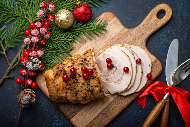 Christmas baked ham sliced with red berries and festive