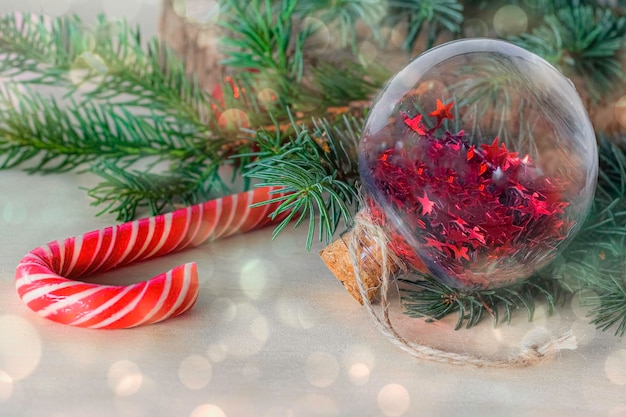 Christmas ball and cane near the Christmas tree with festive decoration