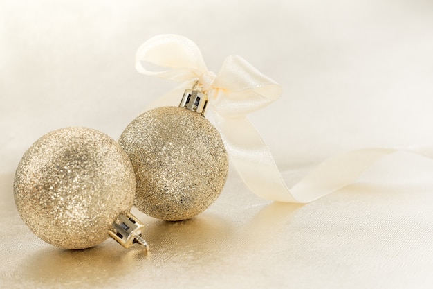 Christmas ball with a bow on the ribbon. Decoration for holiday greetings. The ball with the ribbon is blurred.