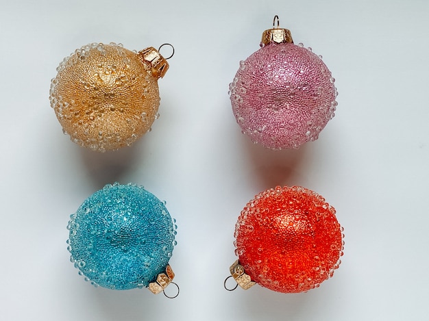 Christmas balls of different colors, red, blue, yellow and pink on a white background. Christmas concept.