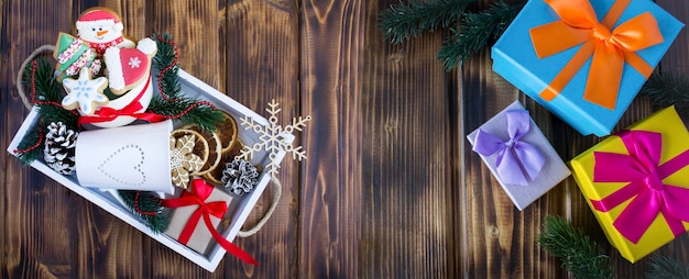 Christmas banner Christmas gingerbread in the white tray and gift box on on the wooden background Top view Copy space