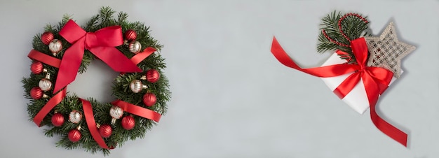 Christmas banner Christmas wreath and gift box on the gray background Top view Copy space