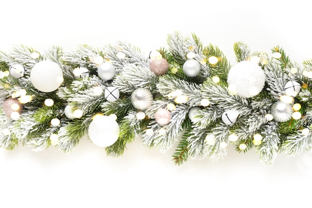 Christmas banner of garland with white baubles on snowy evergreen branches