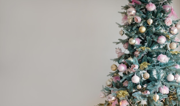 Christmas banner with Christmas tree Christmas tree with lights and pink and golden decorations on a light background Christmas concept with copy space place for text