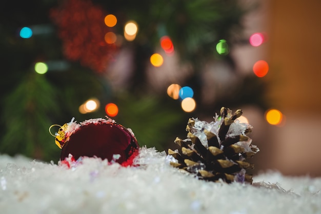 Christmas bauble and pine cone on snow