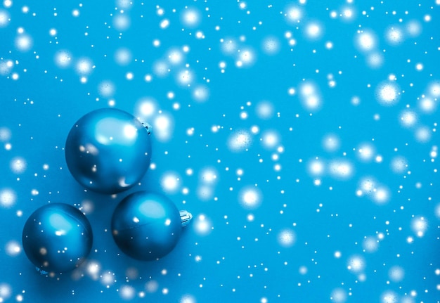 Christmas baubles on blue background with snow glitter luxury winter holiday card