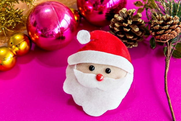 Christmas baubles and Santa Claus on pink background.