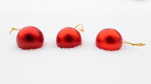 Christmas baubles in the snow three red baubles