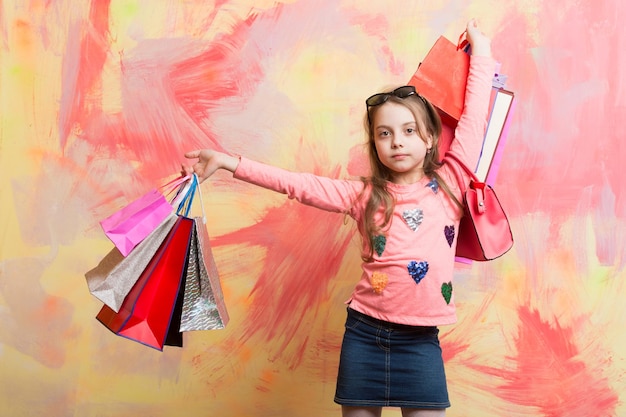 Christmas and birthday Holiday celebration and party Child girl with present pack on colorful background Childhood and happiness Small girl with shopping bag