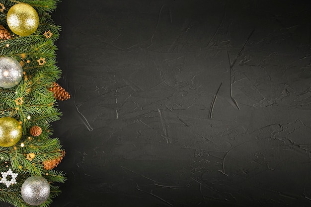 christmas black background with fir branches, cones and balls