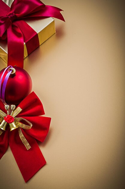 Christmas bow ball gift box on golden background holidays concept