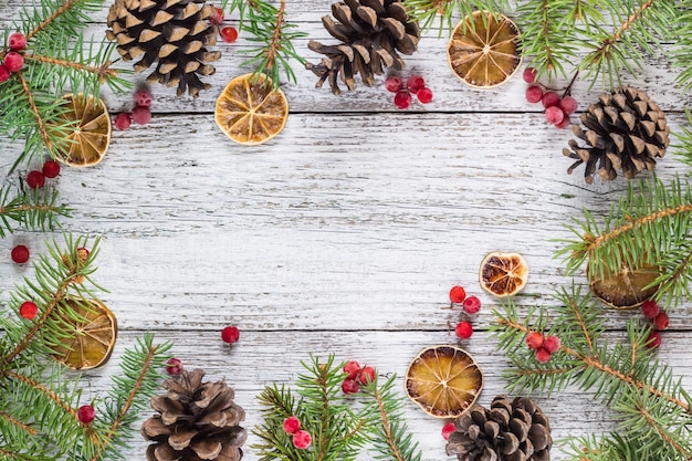 Christmas branches frame background with cones viburnum berries and dry lemon slice