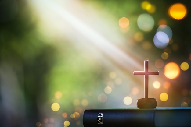 Christmas bright light background with bible and crucifixion of Jesus Christ and lights bokeh backgr