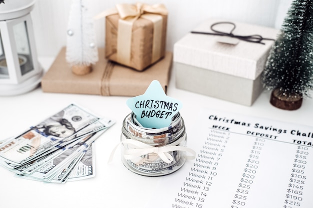 Photo christmas budget, christmas savings challenge. xmas savings, savings challenge, saving money concept with dollars bills and savings challenge list