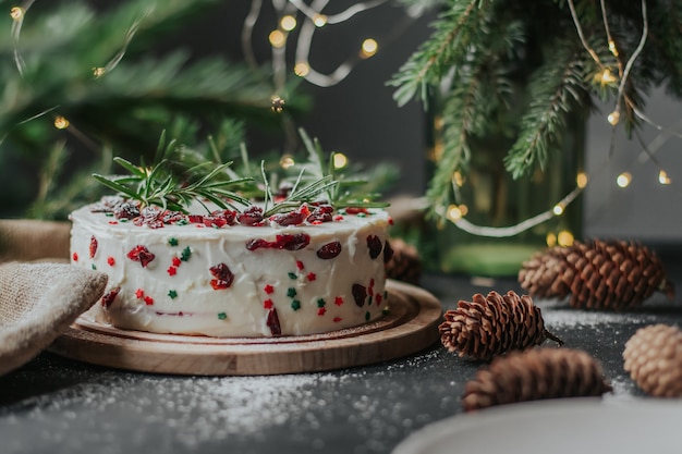 Christmas cake with white cheese cream, decorated with cranberries and rosemary.