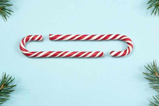 Christmas candies and fir branches on a blue background