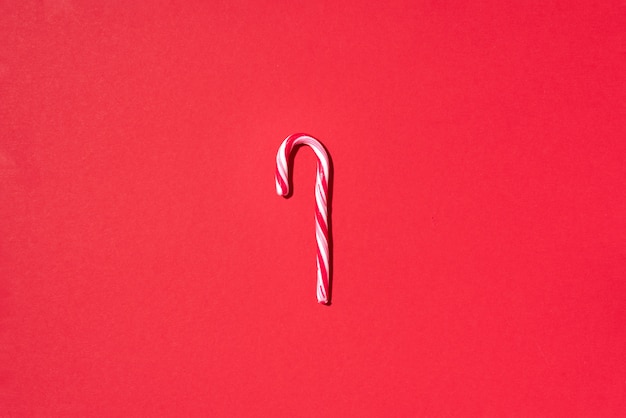 Christmas candy cane on red background