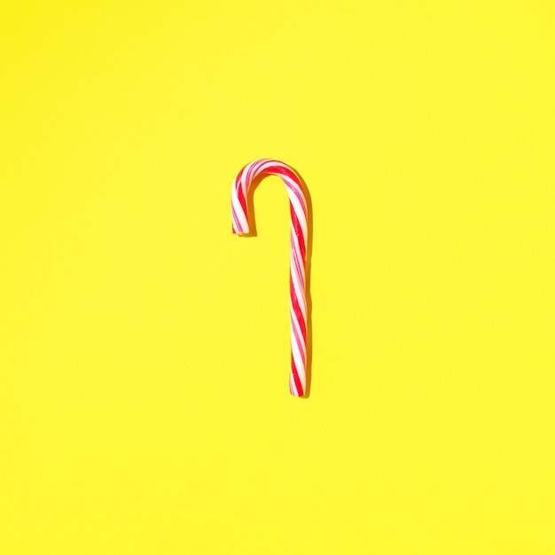 Christmas candy cane on yellow background