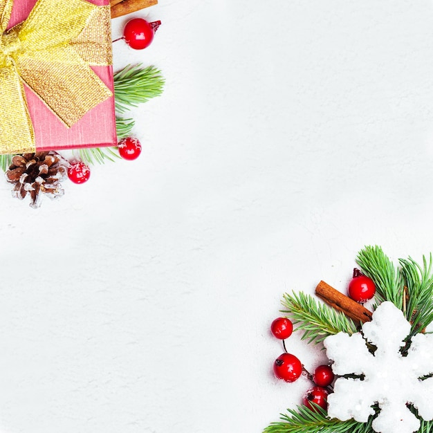 Christmas card background border composition with green Xmas fir branch red holly berries and baubles on white background