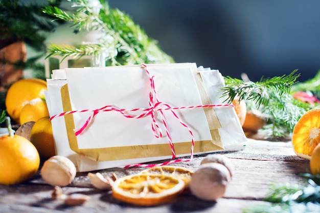 Christmas card Merry Christmas and Happy New Year theme. Letter, spruce, lantern, tangerines, nuts on wooden background.