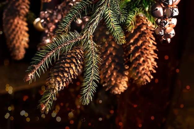 Christmas card with a spruce branch big cones and toys from pink bells for Christmas and New Year