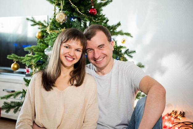 Christmas celebration. Family in room with Christmas tree.