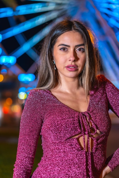 Christmas in the city winter at night decoration Portrait of a young brunette on an illuminated Ferris wheel