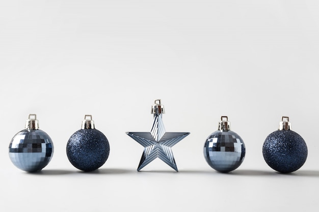 Christmas classic blue balls ans star in row on neutral pastel grey