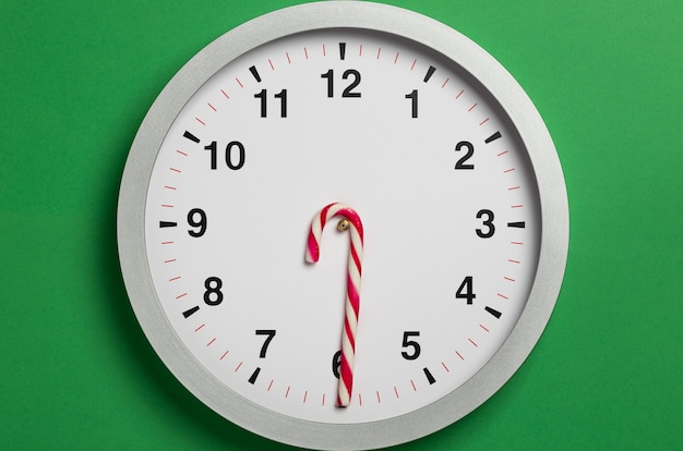 Christmas clock with candy cane hands shows six oclock